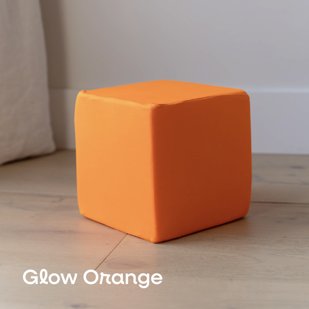 Orange cube on a wooden floor with 'Glow Orange' text